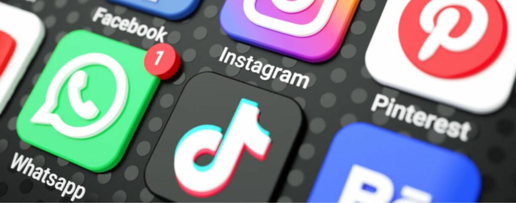Icons of popular social media applications including Facebook, Instagram, Pinterest, WhatsApp, and TikTok on a smartphone screen, showcasing the modern digital communication landscape.